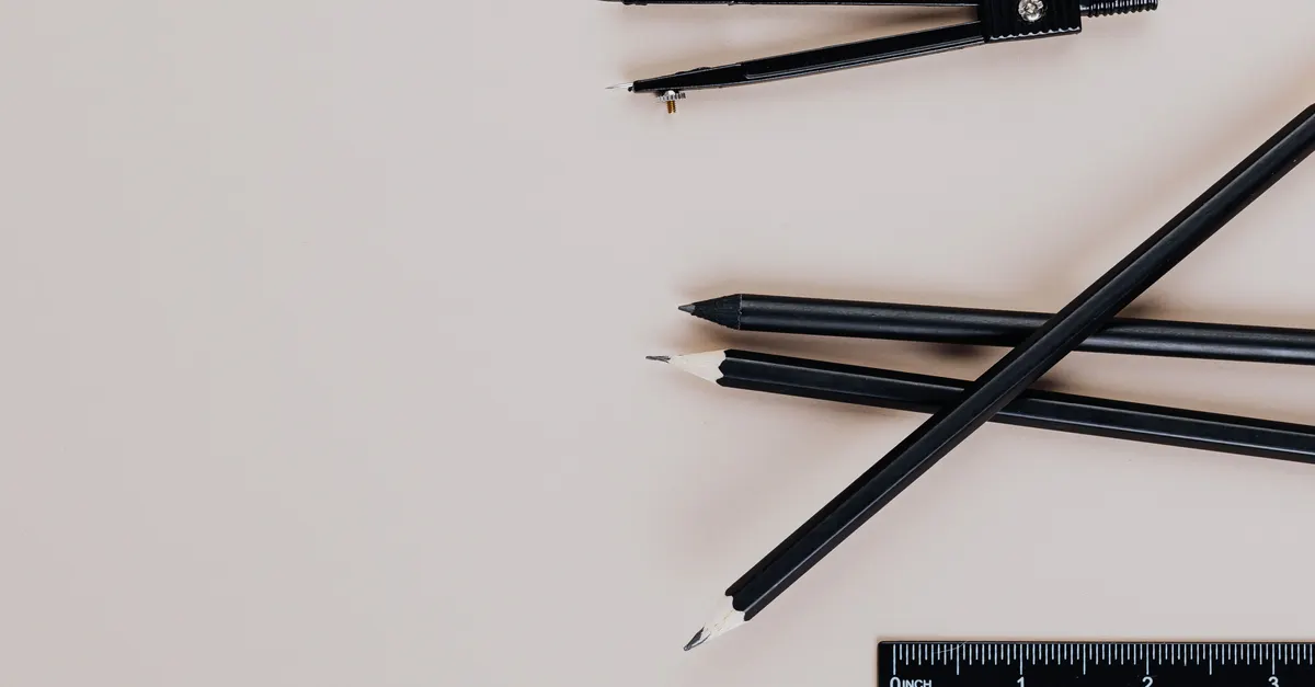 Pencils and a compass on a drafting desk, for planning reference planes before geometry