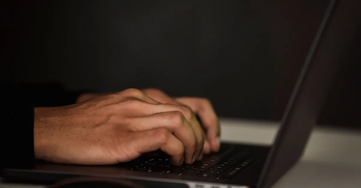 Hands on a laptop keyboard in a dark room, for building a Revit model checker checkset