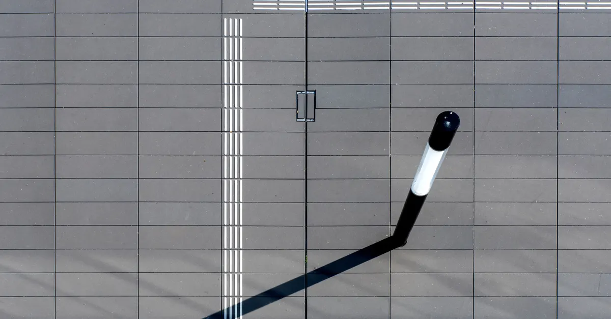An overhead view of a pavement with a branching line, standing in for the choice between buying and building