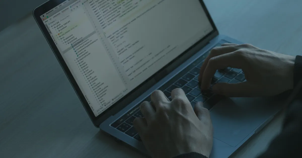 Hands typing code on a laptop, standing in for choosing between a Dynamo script, a Revit API add-in, and Forge